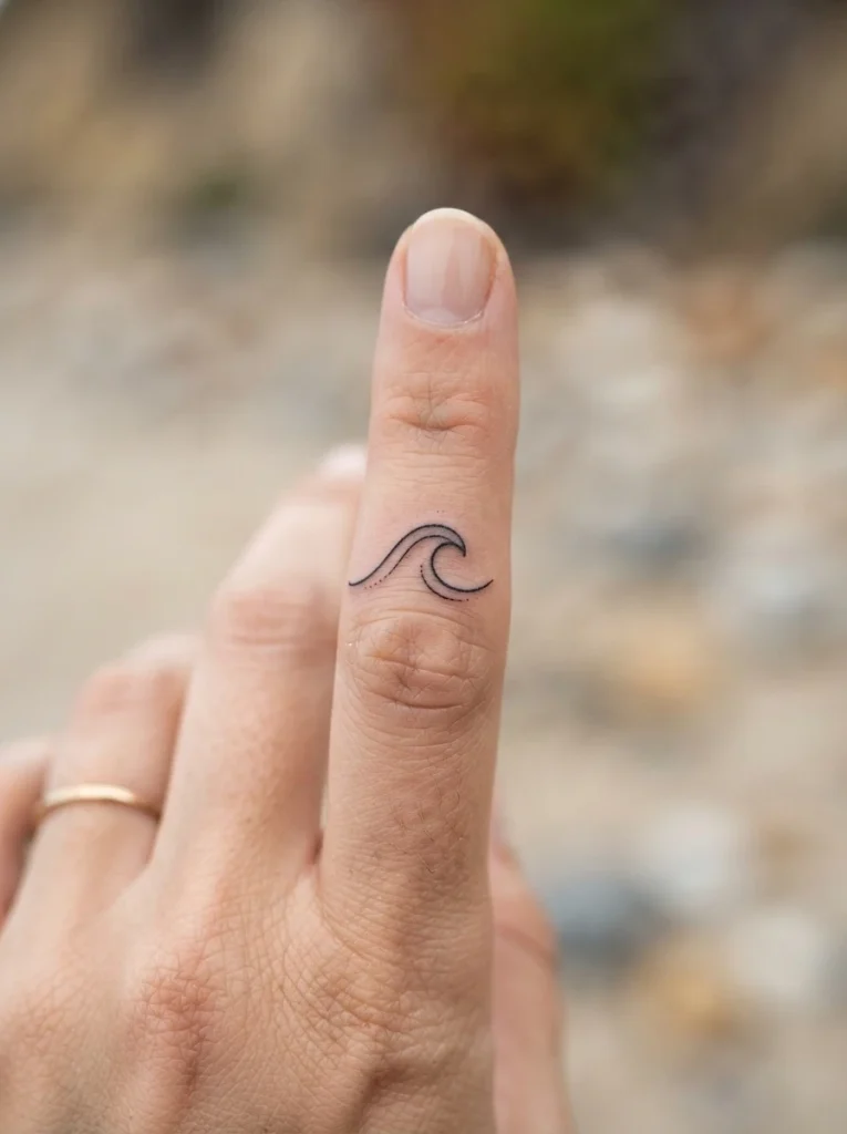 14. Tiny Wave Finger Tattoo